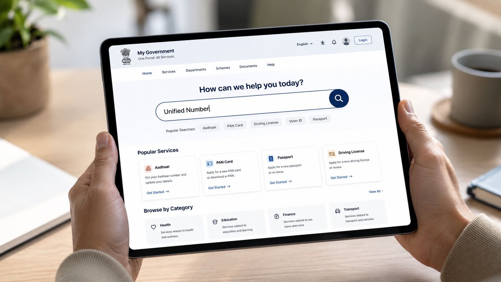 A person holding a tablet displaying the My Government website with a search bar for services.